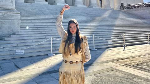 Photo of Samantha Maltais in front of the Supreme Court in some of her Traditional Regalia
