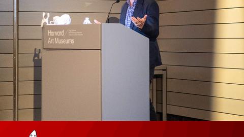 A photo of David Treuer standing at a podium speaking